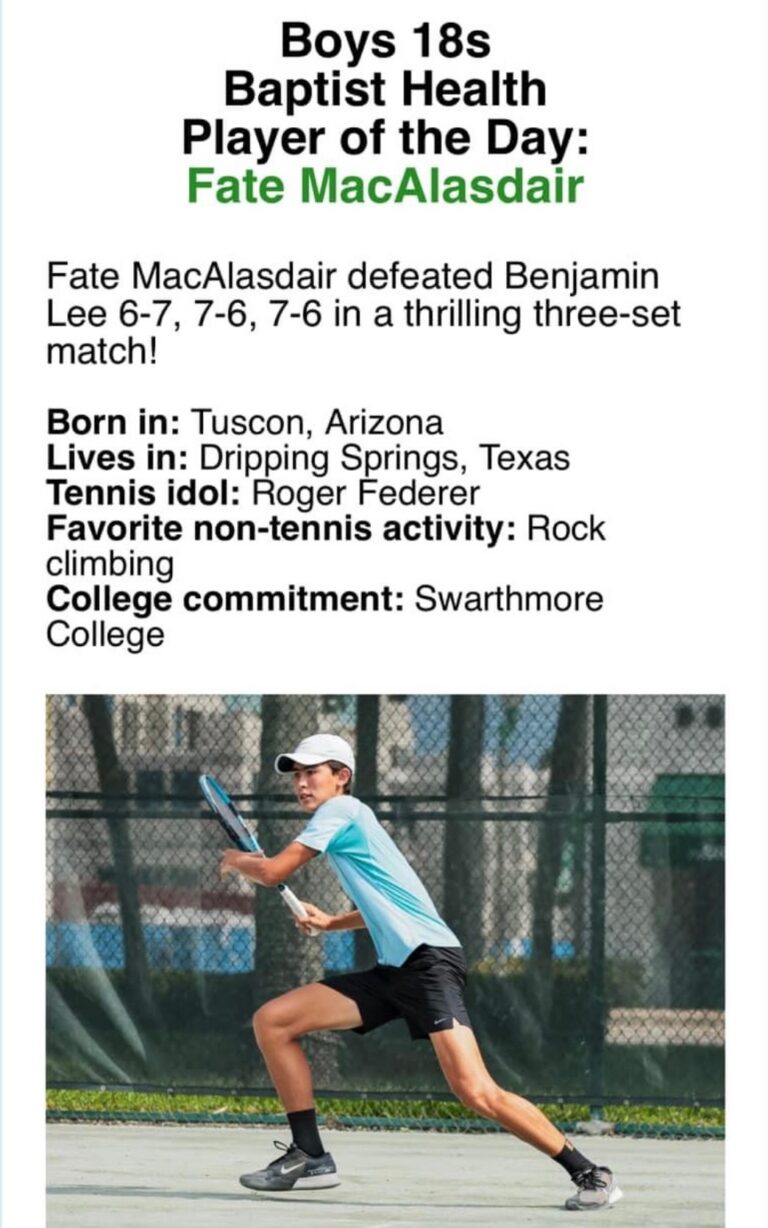 Young male tennis player in blue shirt and white cap prepares to hit a backhand on an outdoor court.