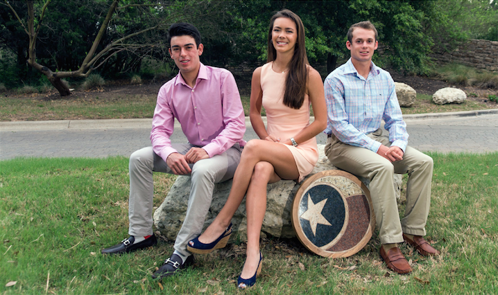 Three young adults sit on a rock outdoors, smiling, with a Texas star emblem next to them.