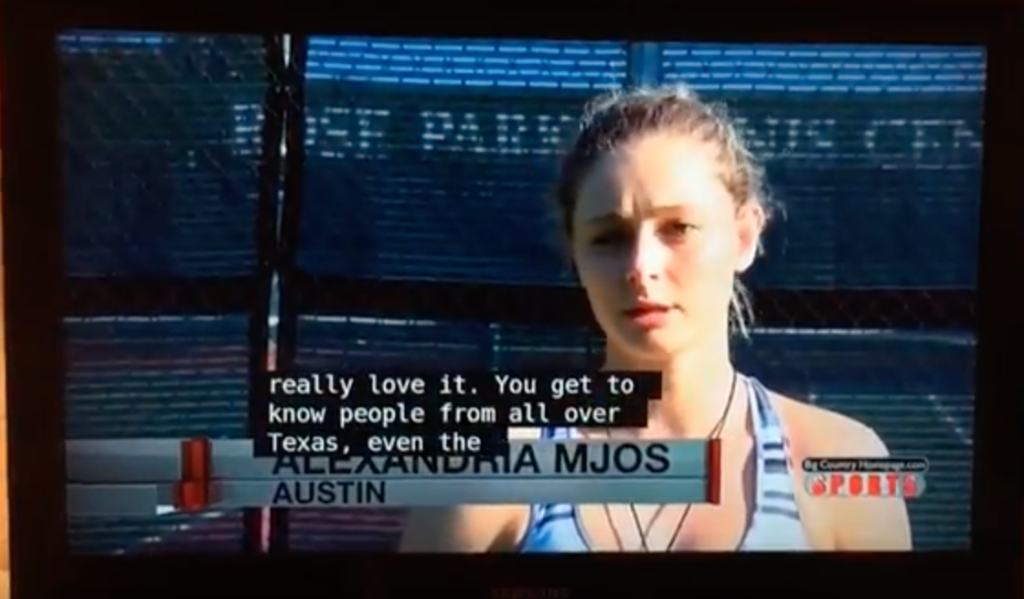 A young woman stands on a tennis court, identified as Alexandria Mjos from Austin, with subtitles displayed.