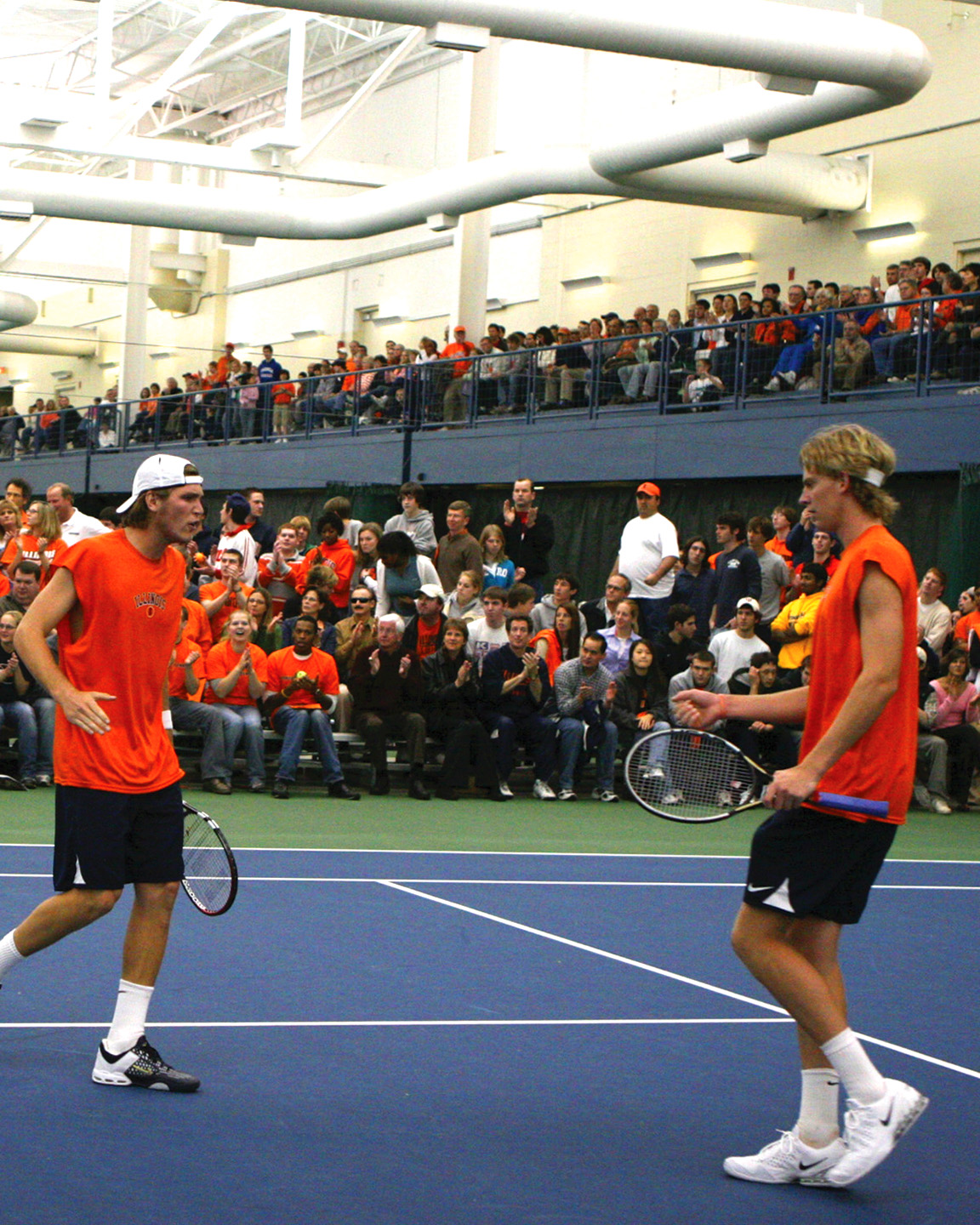 Two tennis players celebrating on indoor court
